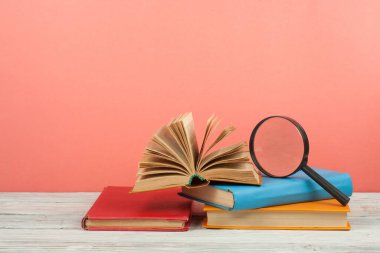 Açık kitap, ahşap masa üzerinde renkli ciltli kitap. Büyüteç'i. Okula dönüş. Metin için yer kopyalayın. Eğitim iş kavramı