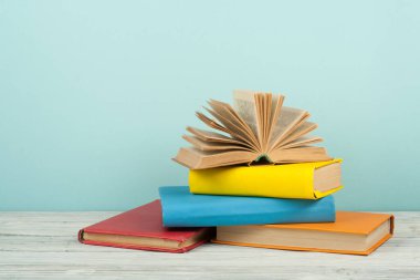 Açık kitap, ahşap masa üzerinde renkli ciltli kitap. Okula dönüş. Metin için yer kopyalayın. Eğitim iş kavramı