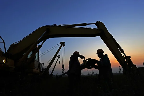 günbatımı üzerinde iki amele silüeti