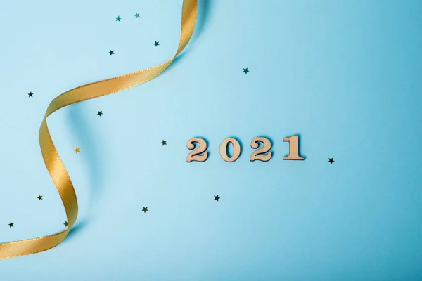 Flatlay Christmas . 2021 from the numbers.The layout of the new 2021. Wooden numbers. Hello new year. Article about new year and Christmas. Keyboard layout. Copy space. Stars. blue background.
