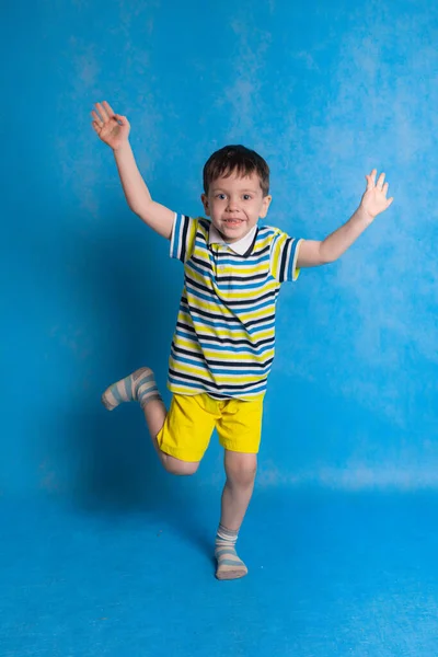 Jongen Springt Een Blauwe Achtergrond Emoties Van Een Kind Grappige — Stockfoto