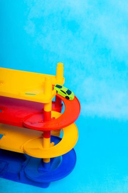 Küçük çocuklar için mavi arka planda park etme oyunu. Erkekler için oyun. Plastik oyunlar. Sokak dışı otopark. Erkekler için oyunlar hakkında makale