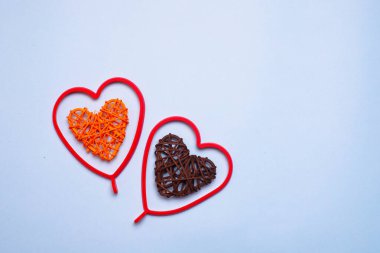 Mavi arka planda renkli kalpler. Kalpler rattan yapılmış. Tatil günü. Sevgililer Günü. Annelerin tatili. Uzayı kopyala Yazı için yeri olan pankart. Sevgililer Günü 'yle ilgili bir makale. Mavi arkaplan