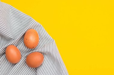 Chicken eggs on a yellow background. Chicken eggs. Article about eggs benefits and harms. Copy space. Yellow background. Food products. The ingredient. clipart