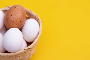 Sarı arka planda tavuk yumurtası. Tavuk yumurtası. Yumurtaların faydaları ve zararları hakkında bir makale. Uzayı kopyala Sarı arka plan. Yiyecek ürünleri. Malzeme.