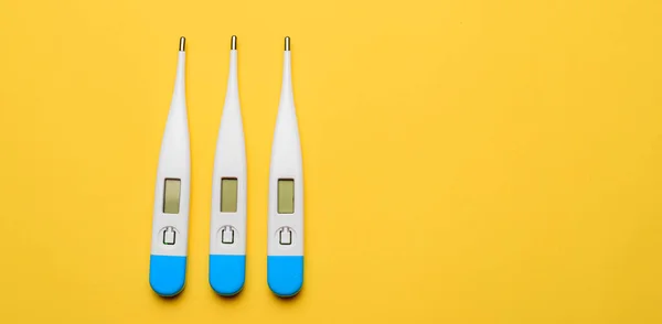 Electronic thermometers . Electronic thermometer on a yellow background. Temperature measurement. Safe thermometer. Modern medical equipment. Science and medicine. Article about safe thermometers. Technologies. Yellow background . Copy space