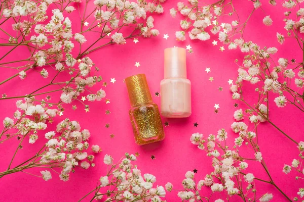 Layout of nail polish and flowers . Nail polish. Painting the nails. Manicure and pedicure. Article about the choice of varnish . The article is about the manicure. Content for a manicurist. Varnish and flowers. Copy space. Photos of the beauty indus