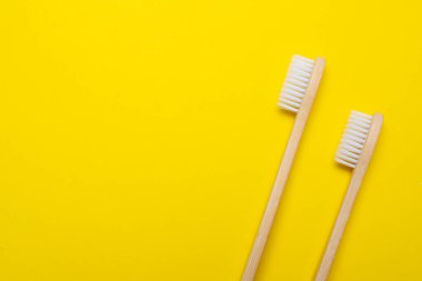 Sarı arka planda bambu fırçası. Plastik yok. Ekoloji. Etrafındaki dünyayla ilgilenmek. Diş fırçası. Temiz dişler. Sarı arka plan. Uzayı kopyala Çevre bakımıyla ilgili bir makale.