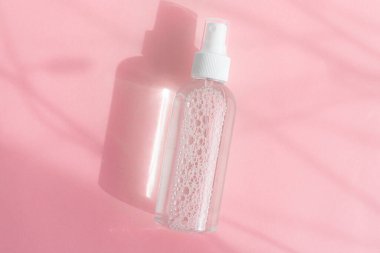 Pembe arka planda antiseptik. El muamelesi. Virüs koruması. Coronavirus. Bir salgın. Pembe arka plan. Işık ve gölgeler. Boşluğu kopyala