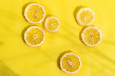 Sarı arka planda limonlar. Dilimlenmiş limon. Sarı meyve. Limon kopyalama alanı düzeni. Sarı arkaplan