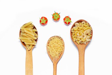 Beyaz arka planda tahta kaşıklarda birkaç çeşit makarna. Tahta kaşıklarda makarna. Beyaz arka planda makarna. Makarna seçimi hakkında makale. Yemek için gerekli malzemeler. Uzayı kopyala İzole edilmiş arka plan. Yiyecek kaynağı. Kiraz domatesleri. 