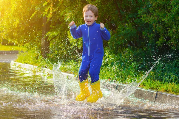 Ein Fröhlicher Junge Gummistiefeln Springt Pfützen Der Junge Springt Eine — Stockfoto