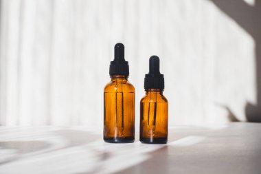 Beyaz arka planda yağlı kozmetik kavanozları. Işık ve gölgeler. Minimalizm. Uzayı kopyala Kozmetoloji. Cilt bakımı. Kozmetik şişeleri. spa tedavileri