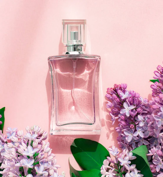 ピンクの背景に香水とライラックのボトル 女性用香水 春の香り アロマセラピー いい匂いだ 美しさとファッション 香りの選択に関する記事 現在の味についての記事 コピースペース ライラックの枝 — ストック写真