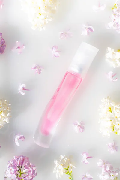 白を基調としたピンクの香水瓶とライラックの枝 香水の広告の概念 テキストなしの香水のボトル 花のアロマセラピーレイアウト スペースのコピー — ストック写真