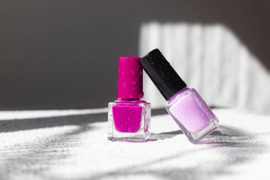 Beyaz arka planda gölgeli tırnak cilası. Yazıtsız oje kavramı. Işık arkaplan ve gölgeler. Uzayı kopyala Vernik seçimi hakkında bir makale. Kozmetoloji