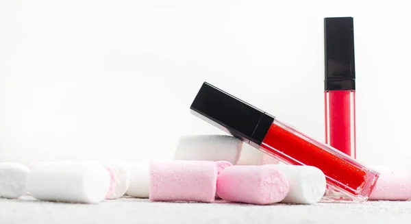 Lipglans en marshmallows. Snoep en glitter. Het concept van cosmetica zonder labels. Decoratieve cosmetica. Schoonheid en mode. Kopieer het kruid. . — Stockfoto