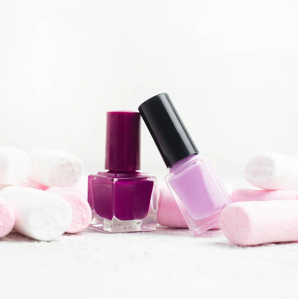 Een fles nagellak en marshmallows. Het concept van nagellak zonder inscripties. Een artikel over de keuze van vernis. Cosmetologie. Kopieer ruimte. — Stockfoto