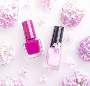 Leylak oje ve bir dal leylak. İsimsiz bir oje şişesi. Lakquer ürünlerinin reklamını yapma fikri. Güzellik ve moda. Tırnak bakımı. Bahar