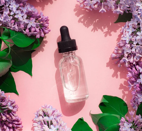 ピンクの背景に香水とライラックのボトル 女性用香水 春の香り アロマセラピー いい匂いだ 美しさとファッション 香りの選択に関する記事 現在の味についての記事 コピースペース ライラックの枝 — ストック写真