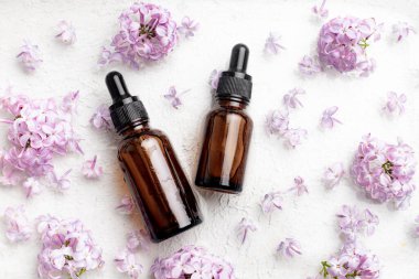 Kozmetik yağ ve leylak dalları için bir şişe. Kozmetoloji. Cilt için kozmetik yağı. Cilt bakımı hakkında bir makale. Leylak dalı
