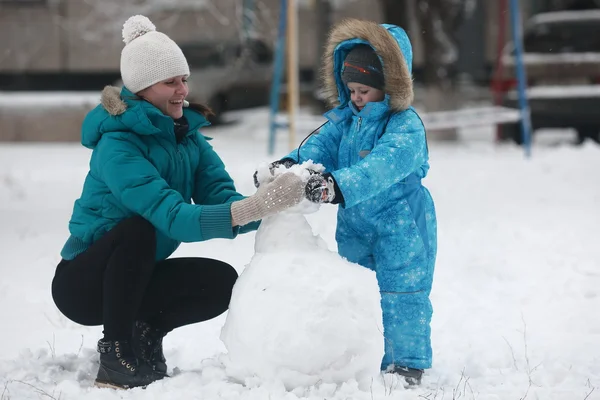 Familie formt Schneemann — Stockfoto