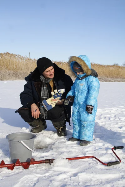 Pesca invernale con il nonno Foto Stock Royalty Free