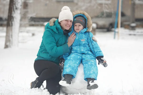 Family sculpts snowman — Stock Photo, Image