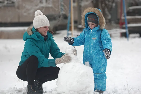 Familie formt Schneemann — Stockfoto