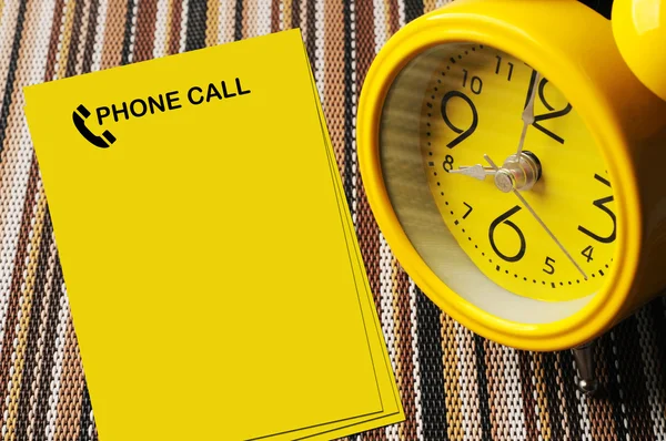 Yellow phone call notes beside close up retro alarm clock on col — Stock Photo, Image