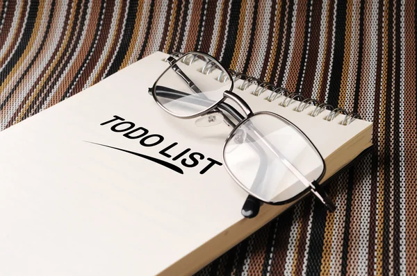 Spectacles on the notepad on the color mat — Stock Photo, Image