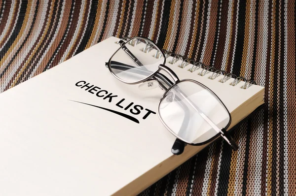 Spectacles on the notepad on the color mat Stock Picture