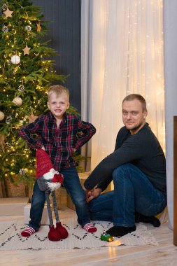 Oturma odasında Noel ağacı olan güzel bir aile.