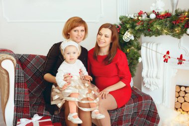 Oturma odasında Noel ağacı olan güzel bir aile.