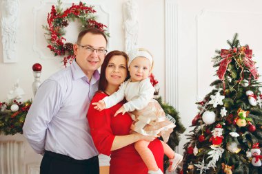 Oturma odasında Noel ağacı olan güzel bir aile.