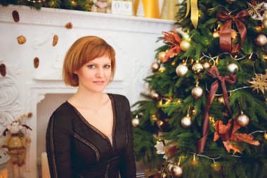 Beyaz odada Noel ağacı olan güzel bir kadın.