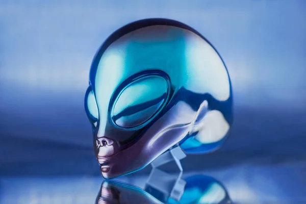 Alien metal head statue on blue background on the table — Stock Photo, Image