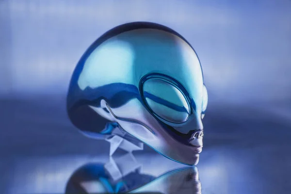 Alien metal head statue on blue background on the table — Stock Photo, Image