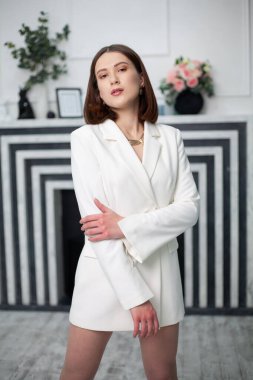 Parlak bir odada beyaz ceketli güzel bir kadın.