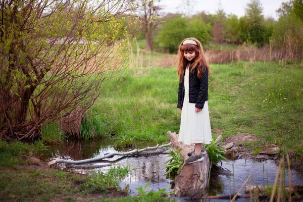 草や花を背景に晴れた春の日に休んでいる女の子 — ストック写真