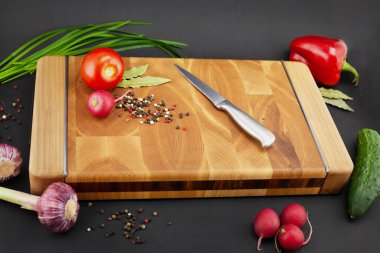 Hafif ve karanlık arka planda sebze ve baharatlı ahşap kalas.