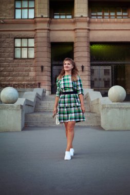 Yaz şehrinde kısa elbiseli mutlu bir kadın.