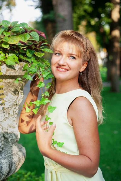 Счастливая женщина в летнем парке в коротком платье — стоковое фото