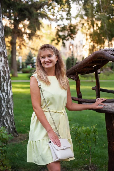 Happy woman in summer park in short dress — Stock Photo, Image