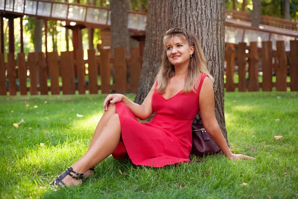 Ευτυχισμένη γυναίκα στο πάρκο το καλοκαίρι με κοντό φόρεμα — Φωτογραφία Αρχείου