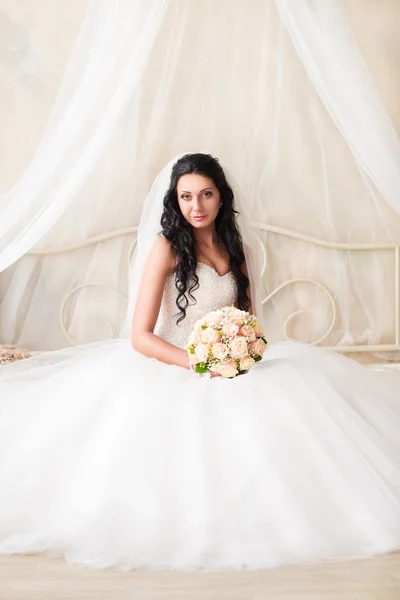 Красивая невеста сидит с букетом — стоковое фото