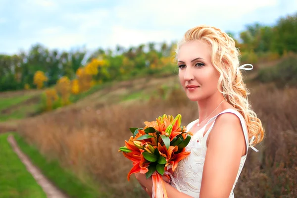 Hermosa novia posando al aire libre con un ramo — Foto de Stock