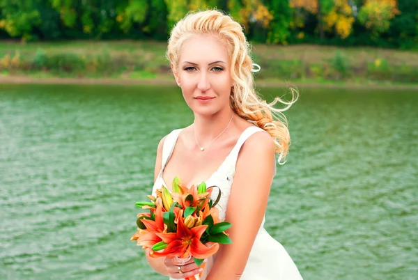 Bella sposa in posa all'aperto con un bouquet — Foto Stock