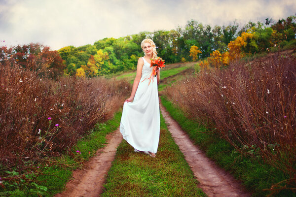 Bride posing outdoors with a bouquet