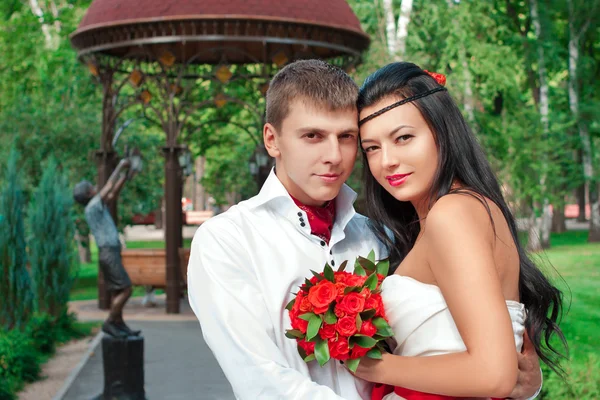 Bride and groom posing in amusement park — Stock Photo, Image